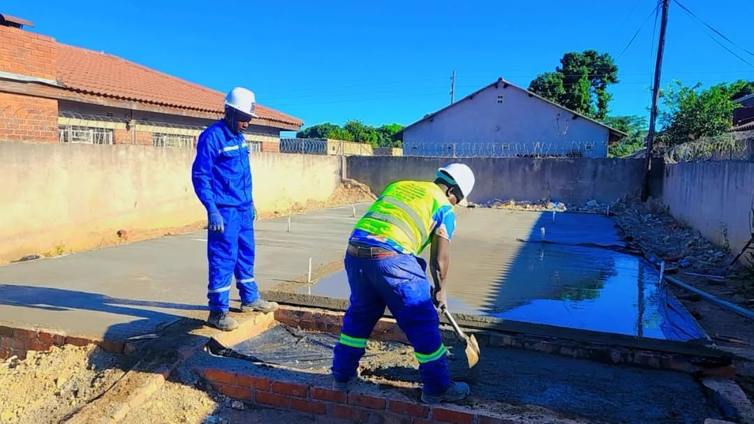DC Designs and Construction team finishing a concrete residential slab in Harare